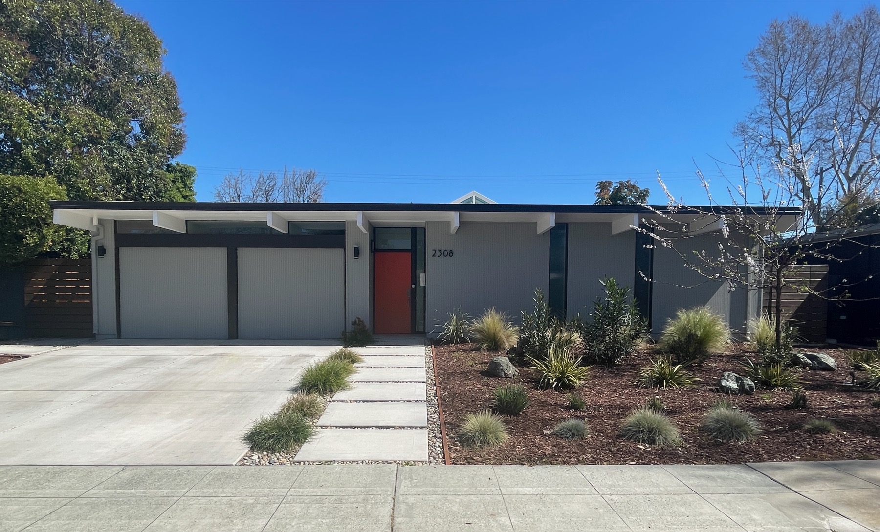 Low-gabled Eichler house on Fairglen Drive in San Jose, with exposed roof structure, clerestory glazing and a double garage.